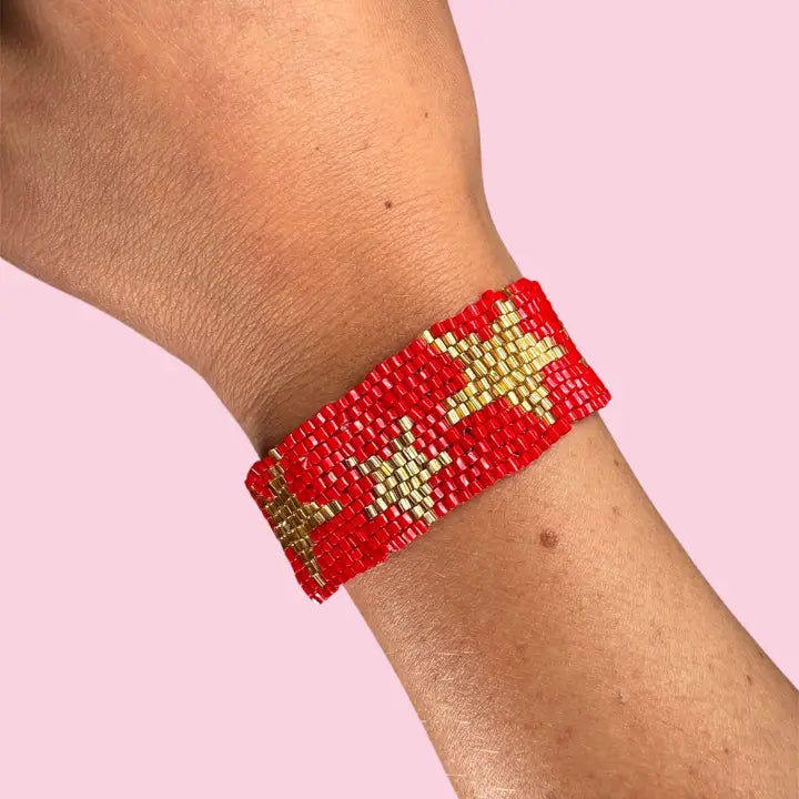 A red beaded bracelet with gold stars