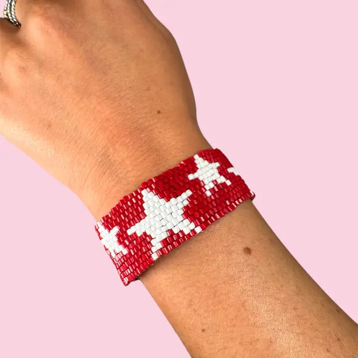 A red and white beaded bracelet with white star patterns