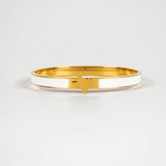 A gold-plated bangle bracelet with a white enamel inlay and a small gold state of  Texas accent at the front