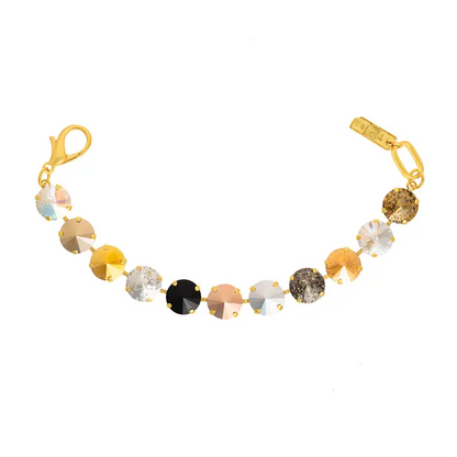 A tova gold-plated bracelet featuring a series of round, faceted gemstones in various colors including gold, silver, black, bronze, and glittery brown, displayed on a clean white background.