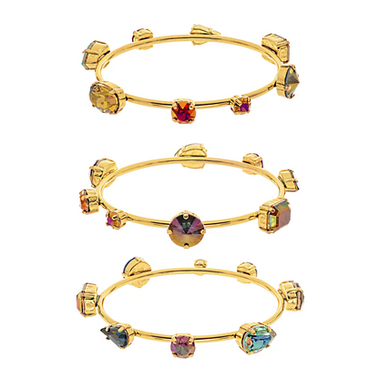 Tova gold bangle adorned with different shaped and colored top quality crystals. 